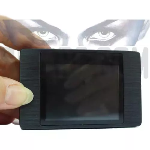 Mini DVR tascabile con monitor LCD del kit microcamera a bottone tenuto tra le dita per evidenziarne la compattezza