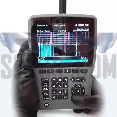 Analizzatore spettro audio per bonifica microspie con guanto - Display che mostra analisi RF e spettrogramma a cascata.