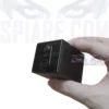 piccola telecamera 4g spia nera a forma di cubo con doppie lenti, tenuta tra il pollice e l'indice. Sull'immagine è presente il testo filigranato 'SPIARE.COM'