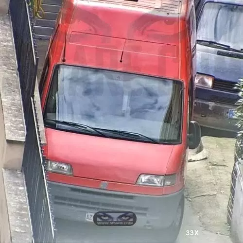 Inquadratura ad alto ingrandimento con zoom 33x sul frontale di un furgone rosso ripresa da telecamera con zoom